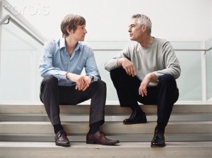 Two Men Sitting on Stairs Talking